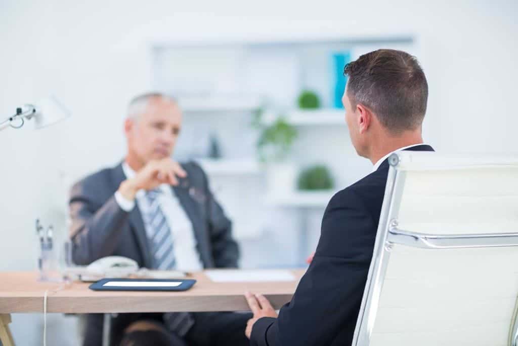 WHS Consultants Sydney 6 Two businessmen sitting and speaking at the office about psychosocial hazards