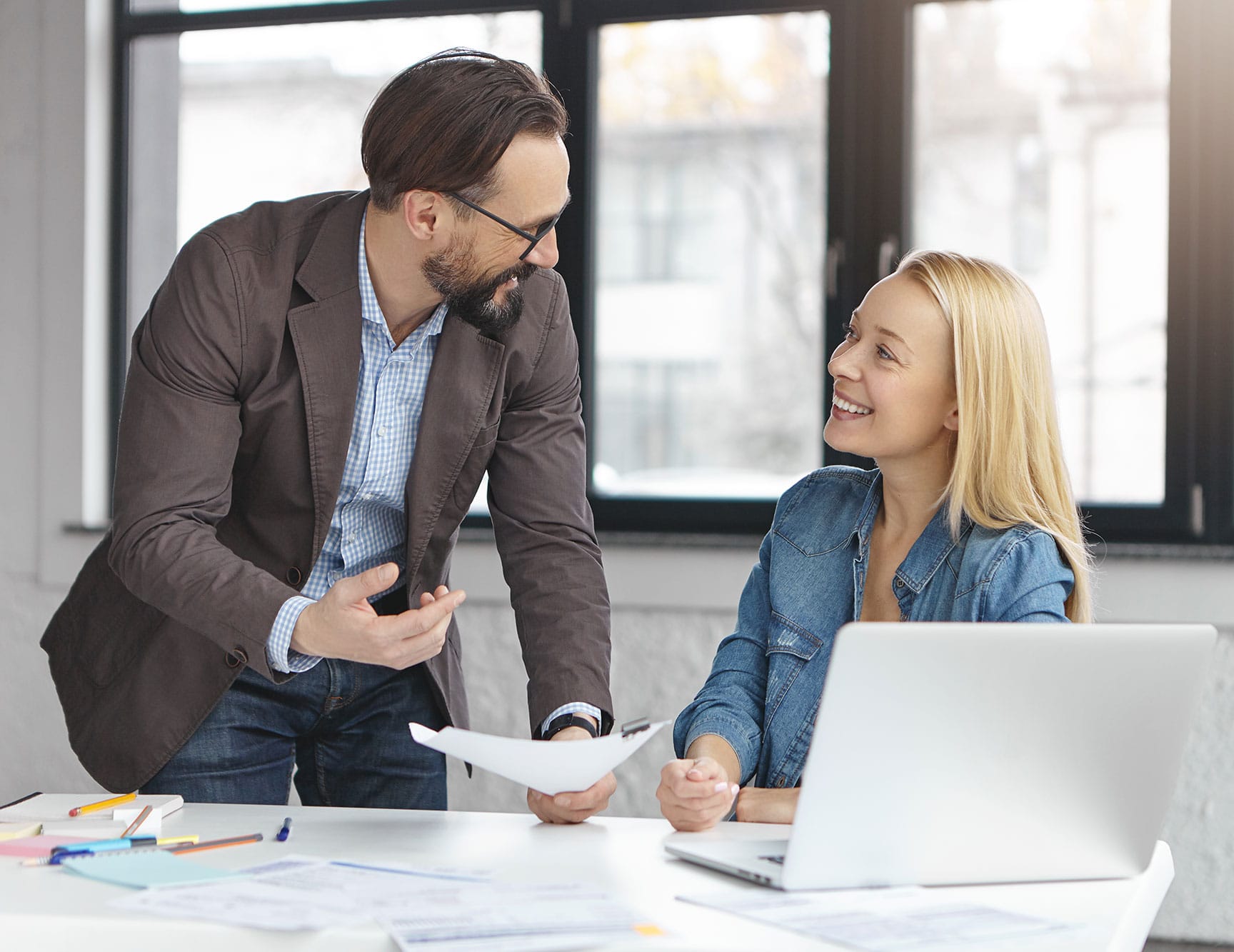 happy blonde female manager has conversation with male colleague