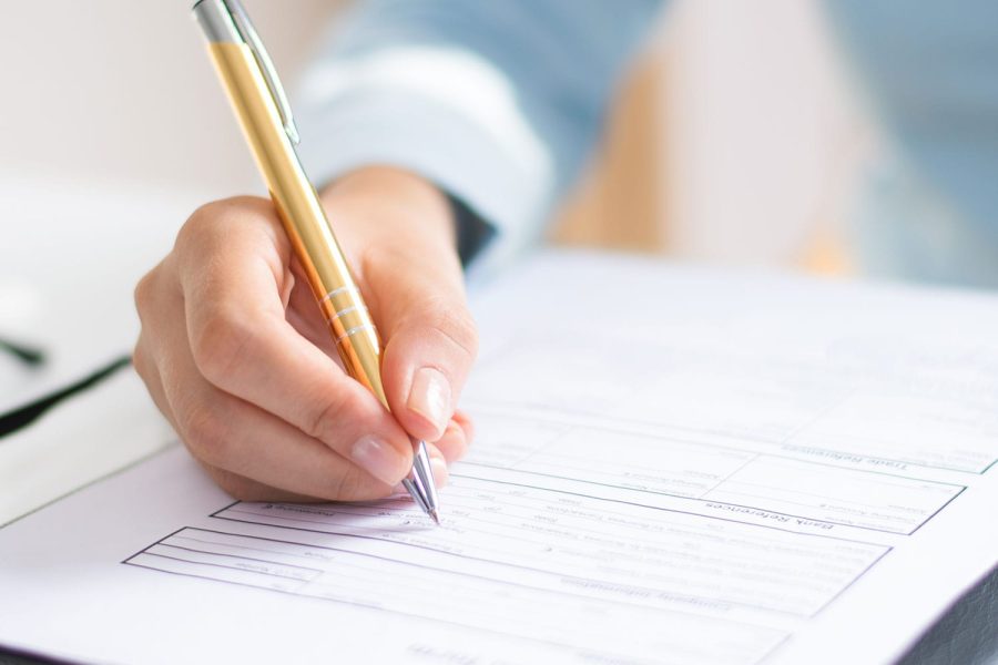 Closeup of business woman making notes in document. Entrepreneur sitting at desk and writing. Paperwork concept. Cropped view.