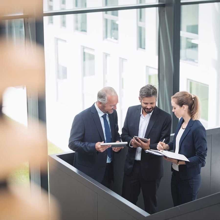 Group of businesspeople having a discussion near staircase in office